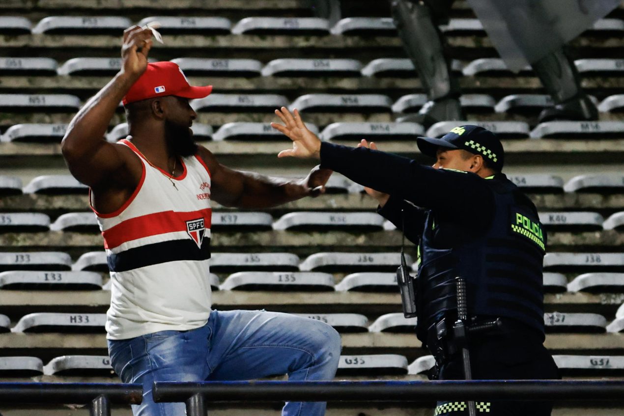 Un fanático del Sao Paulo amenaza con golpear a un policía durante una gresca con seguidores del Atlético Nacional al término del partido de Copa Libertadores jugado este martes en el estadio Atanasio Girardor de la ciudad de Medellín. EFE/Mauricio Dueñas Castañeda
