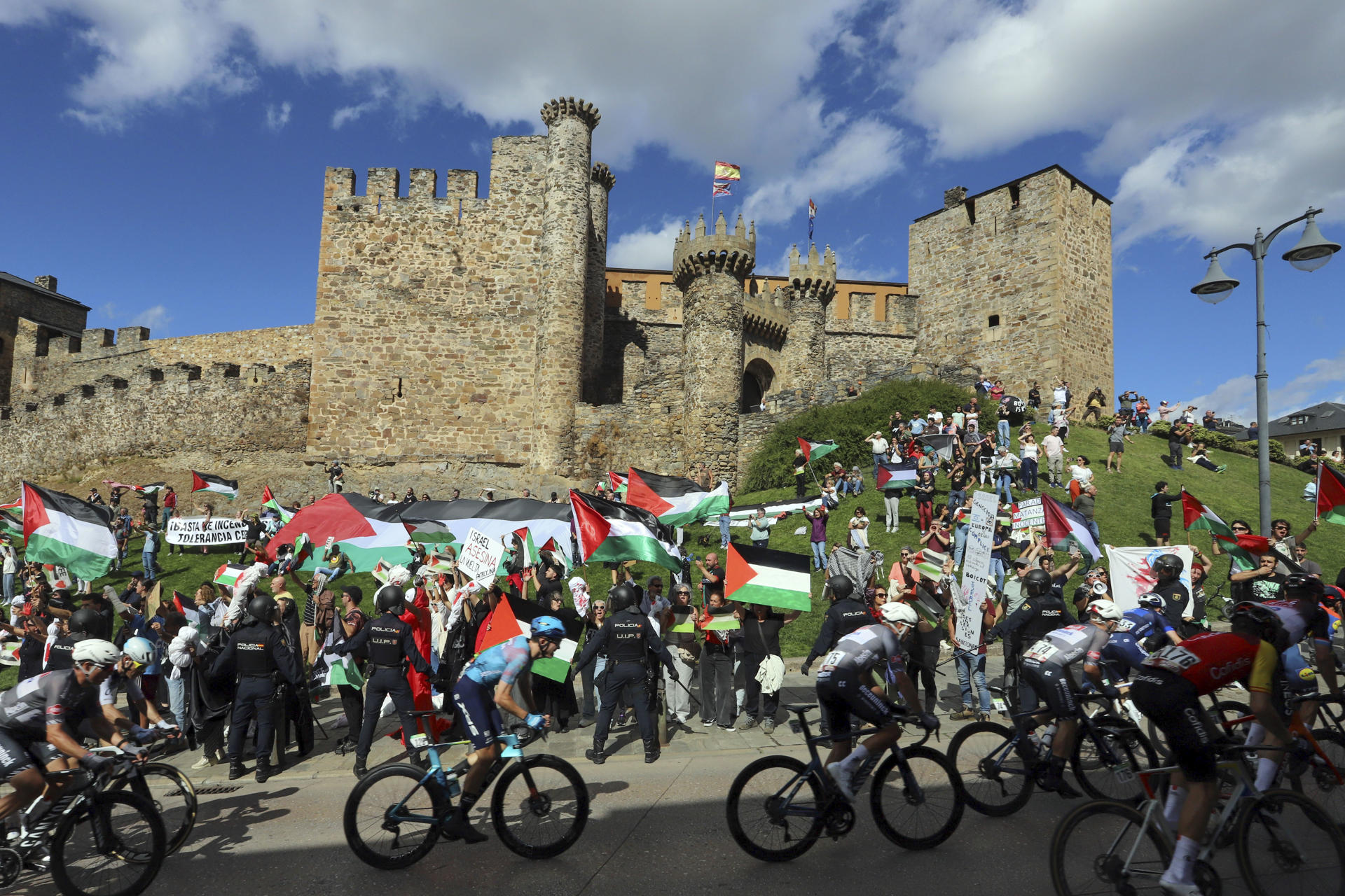 Decenas de personas protestan contra Israel al paso del pelotón por el Castillo de los Templarios en Ponferrada (León), durante la etapa 17 de la Vuelta Ciclista a España, disputada este miércoles entre O Barco de Valdeorras (Ourense) y Alto de El Morredero (EL Bierzo-León) y con 143,2km de recorrido. EFE/Ana F Barredo