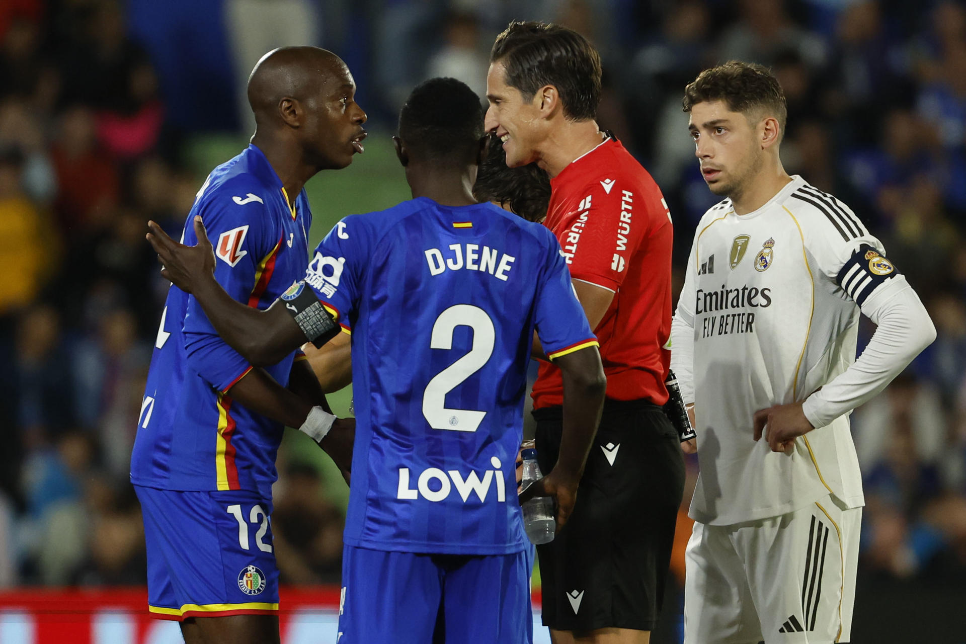 El defensa camerunés del Getafe, Allan Nyom (i), protesta al colegiado Munuera Montero tras ser expulsado durante el partido de la jornada 9 de LaLiga EA Sports que Getafe y Real Madrid disputaron en el Coliseum, en Getafe (Comunidad de Madrid). EFE/Mariscal.