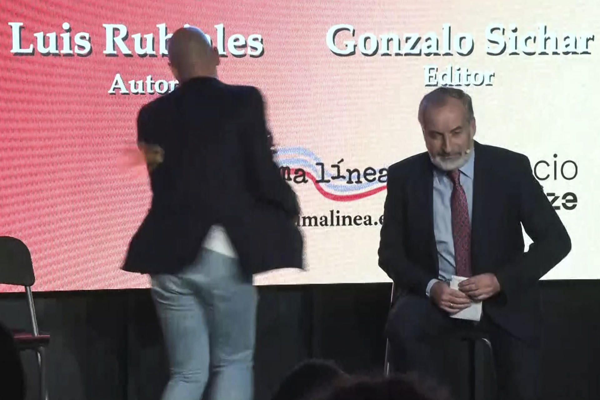 Captura de video del momento en el que Luis Rubiales, expresidente de la Real Federación Española de Fútbol, fue atacado por un hombre que le tiró huevos durante la presentación este jueves de su libro "Matar a Rubiales". Al grito de "sinvergüenza", un desconocido irrumpió en el acto y lanzó dos huevos que esquivó Rubiales. El atacante fue reducido y sacado de la sala y el acto continúa sin más incidentes. EFE/Alberto Lozano