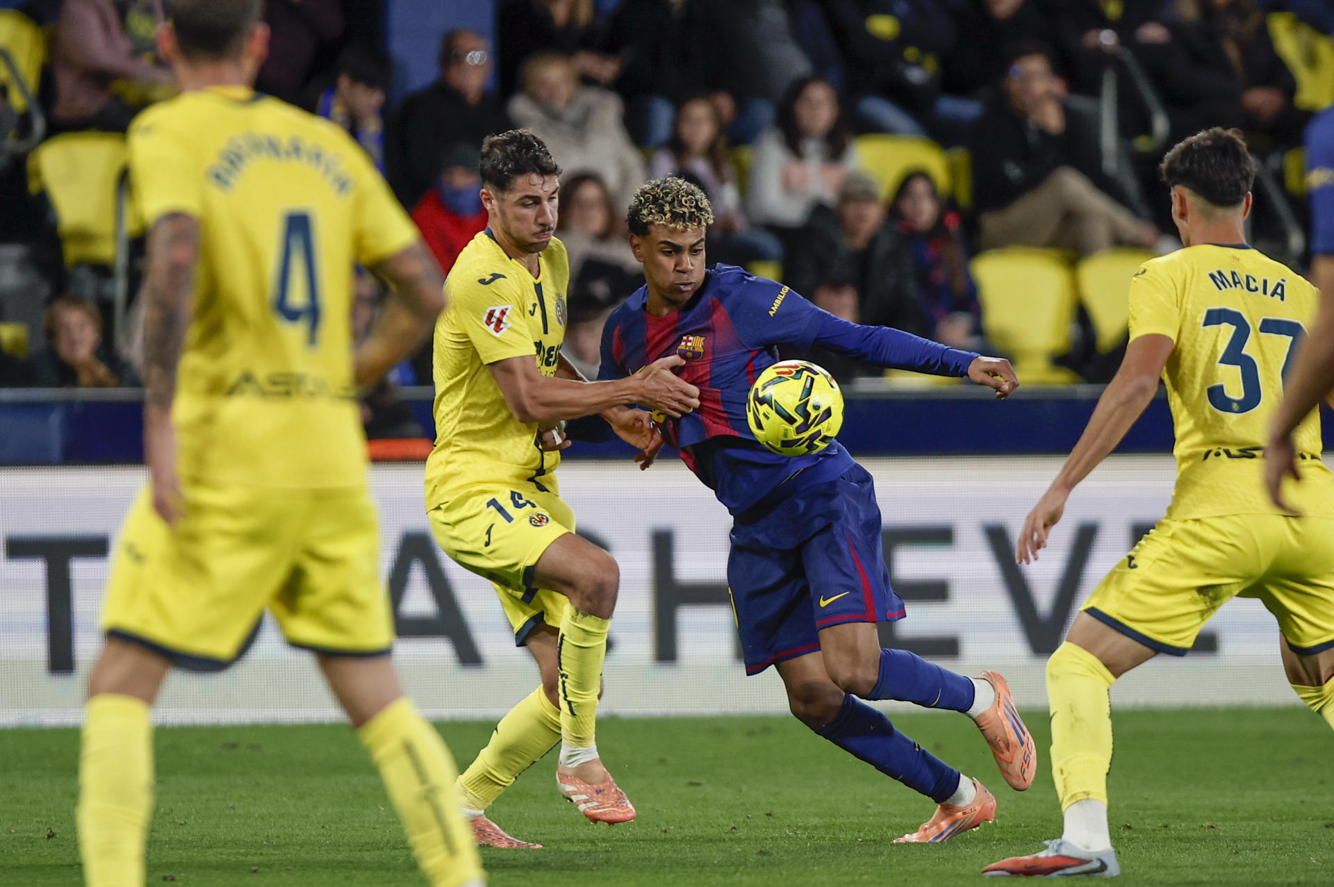 El centrocampista del Villarreal Santiago Comesaña (i) pelea un balón ante el delantero del Barça Lamine Yamal durante el partido de la jornada 17 de LaLiga EA Sports, disputado en el Estadio de la Cerámica. EFE/ Biel Alino