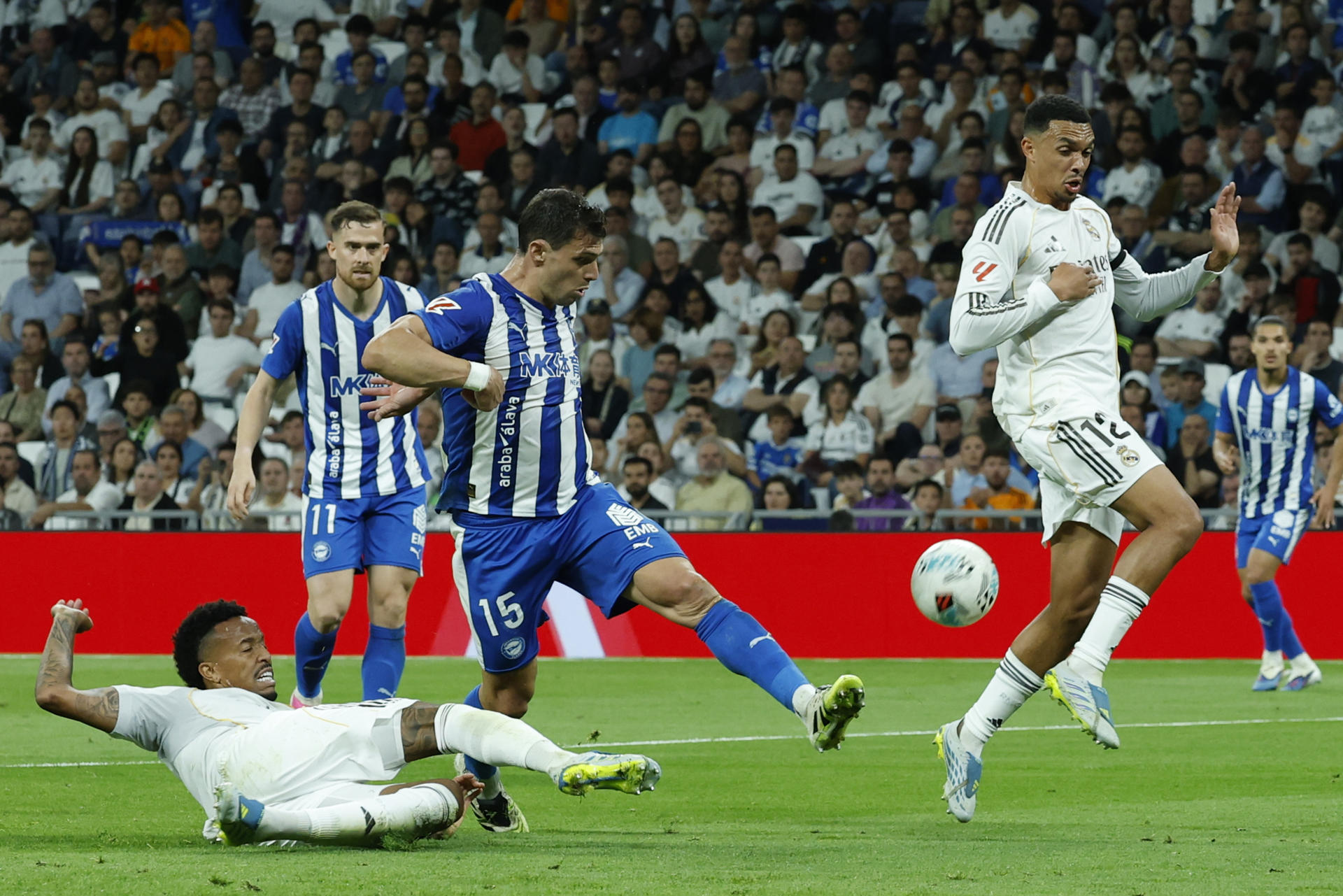 El defensa del Real Madrid Éder Militão (i) disputa un balón ante el delantero del Alavés Lucas Boyé (c), en el estadio Santiago Bernabéu, en Madrid. EFE/ J.J.Guillén