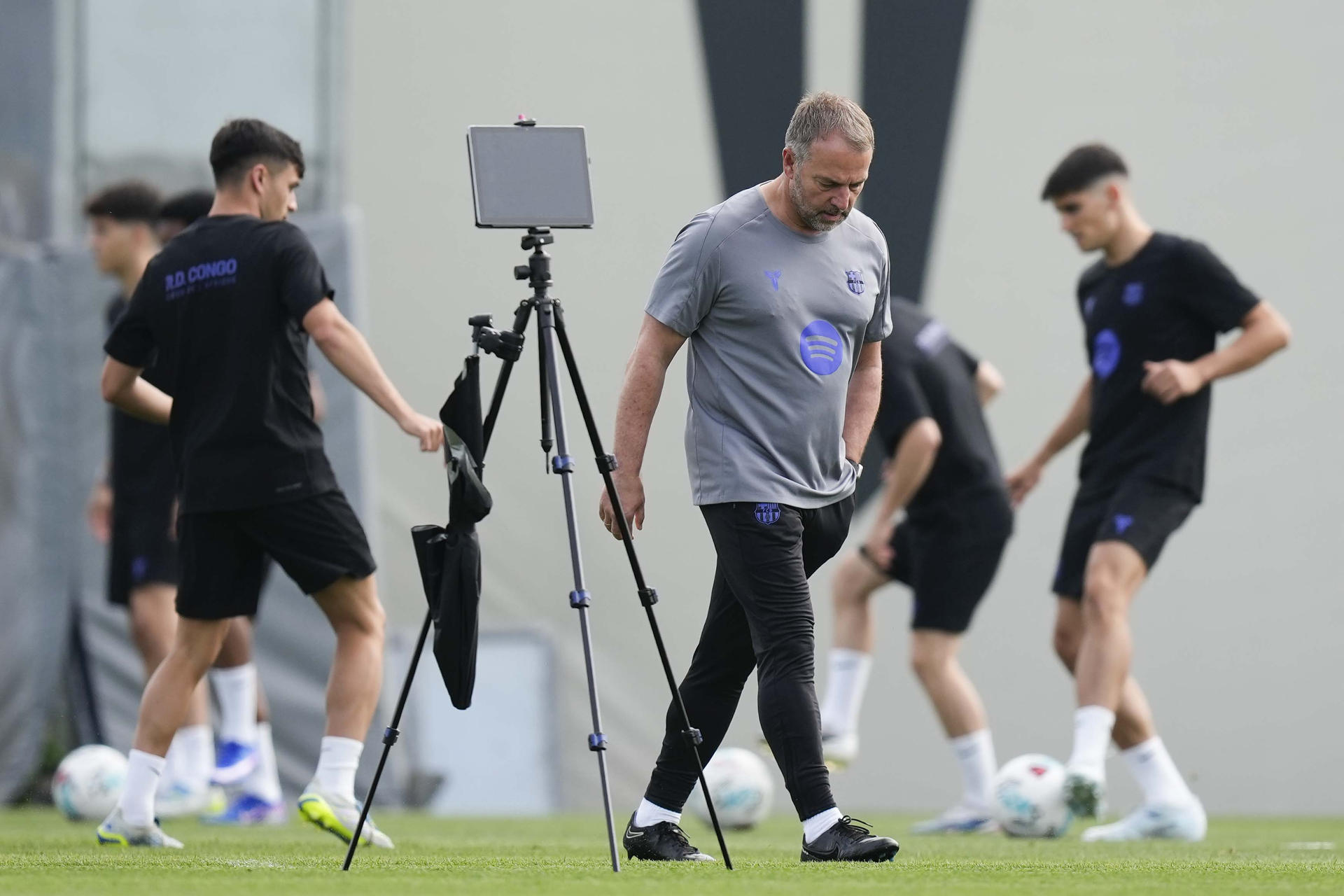 El técnico alemán del FC Barcelona, Hansi Flick (c), dirige el entrenamiento del primer equipo en las instalaciones de la Ciudad Deportiva Joan Gamper, este viernes, en la víspera de su partido de LaLiga EA Sports contra el Osasuna. EFE/ Enric Fontcuberta
