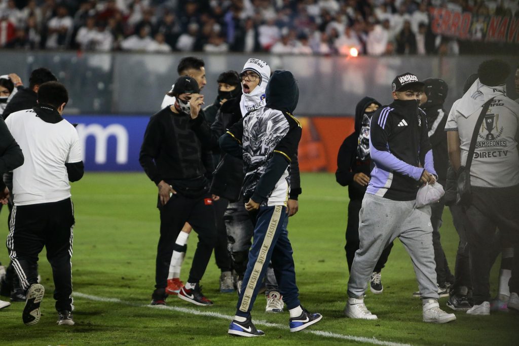 Hinchas de Colo Colo invadieron el campo tras la muerte de dos aficionados asfixiados por una avalancha luego de una carga policial en Libertadores.. EFE/ Osvaldo Villarroel