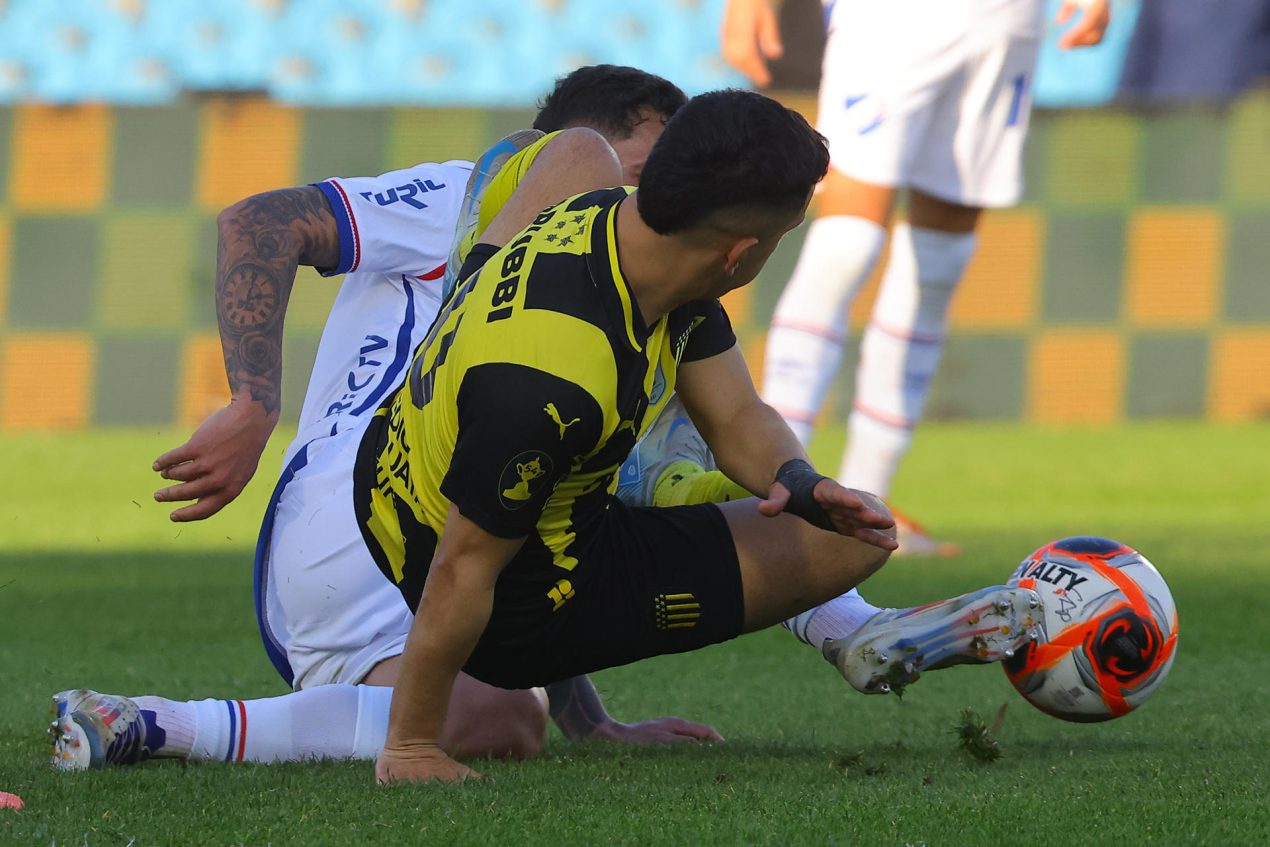 El mediocentro de Peñarol Leo Fernández (d) disputa el balón con el defensor colombiano de Nacional, Julián Millán, durante la final del Torneo Intermedio del fútbol uruguayo que conquistó este domingo el Carbonero en el estadio Centenario de Montevideo. EFE/Gaston Britos