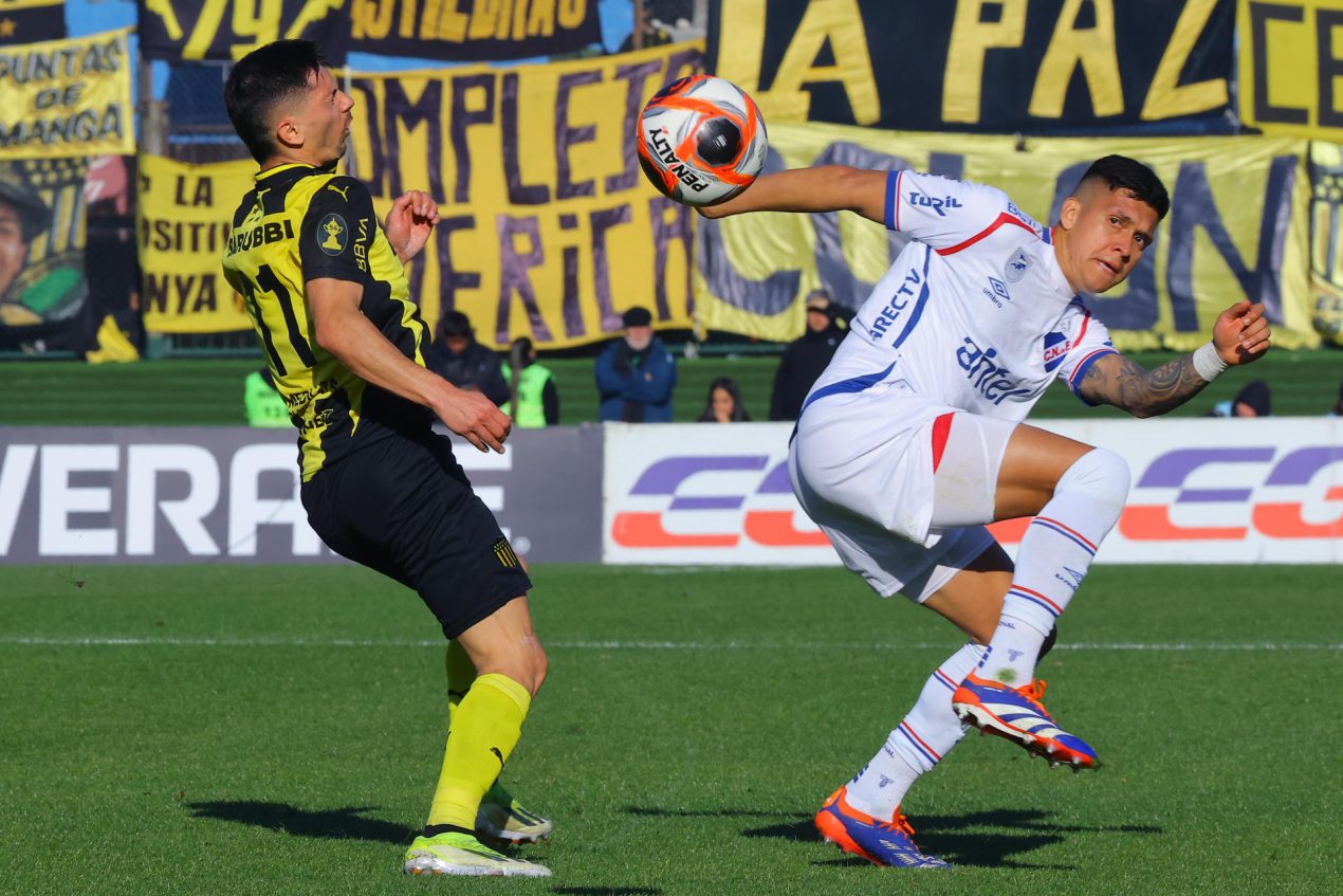 . El delantero de Peñarol Maximiliano Silvera (i) disputa el balón con el defensor colombiano de Nacional, Julián Millán, durante la final del Torneo Intertmedio que el Carbonero conquistó este domingo en una tanda de penaltis en el estadio Centenario de Montevideo. EFE/Gaston Britos