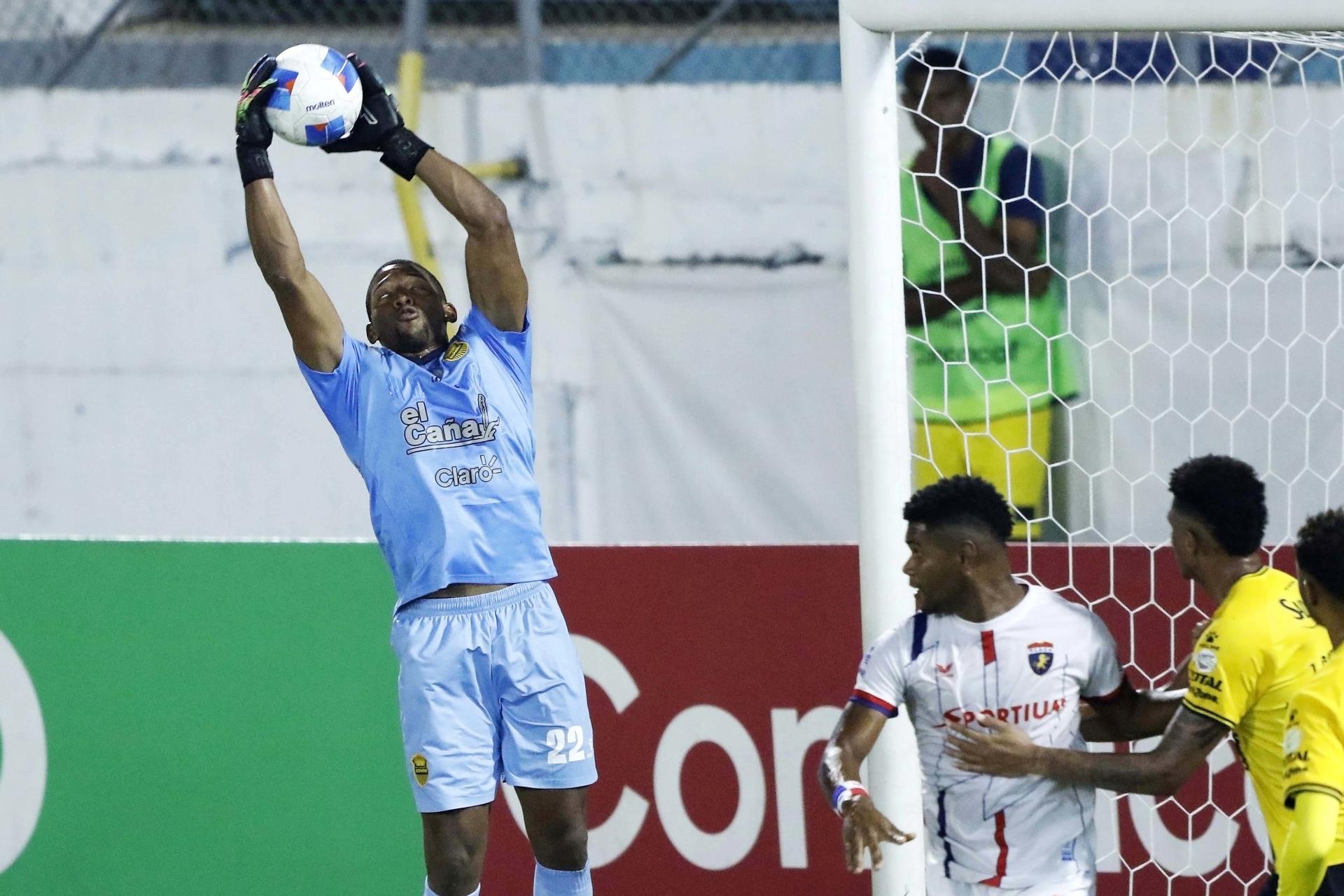 El guardameta Luis López (i) del Real España hondureño controla el balón este miércoles durante el partido que ganó a domicilio por 0-1 en la fase de ida de los cuartos de final de la Copa Centroamericana en San Pedro Sula. EFE/José Valle