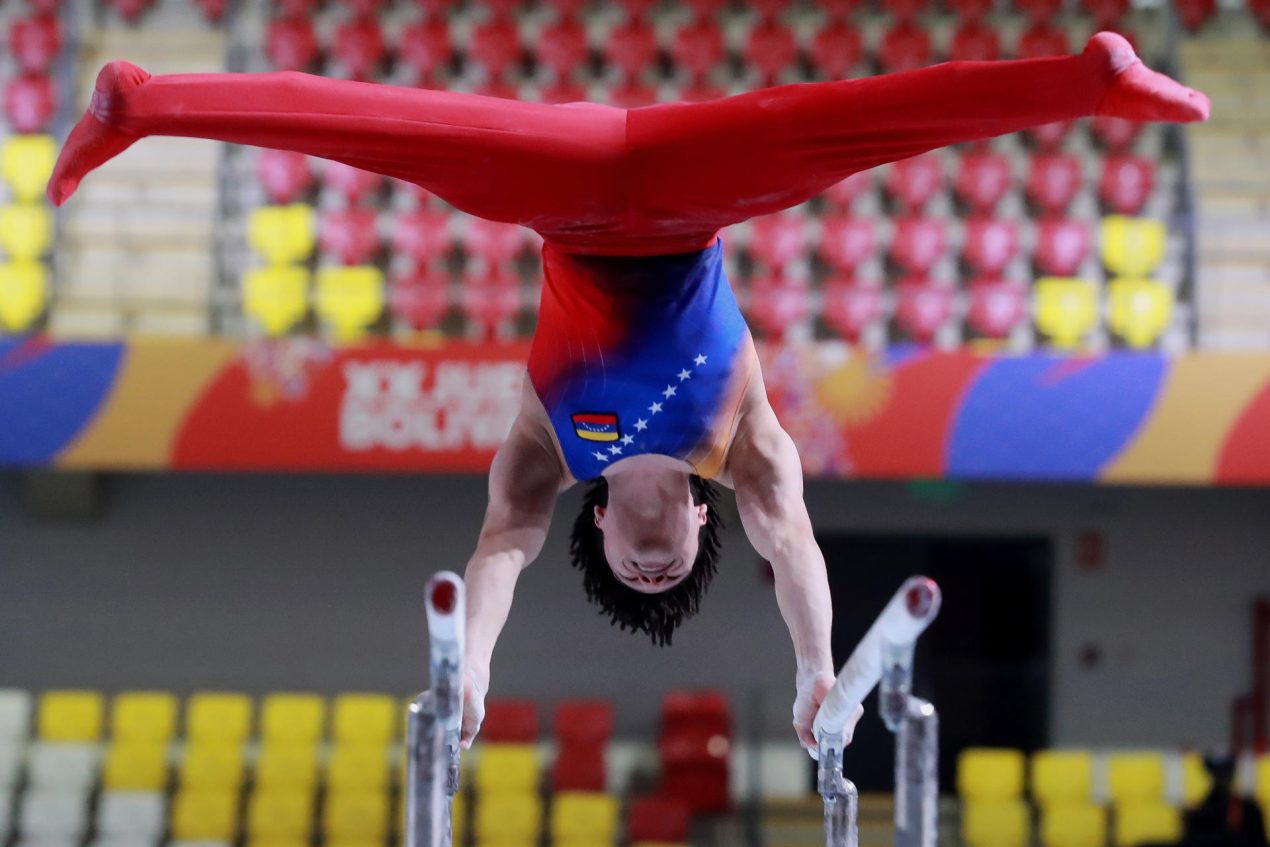 Yefferson Yeguez, de Venezuela, compite en la prueba de barras paralelas en la final general de la gimnasia artística masculina de los Juegos Bolivarianos este jueves, en Lima (Perú). EFE/ STR