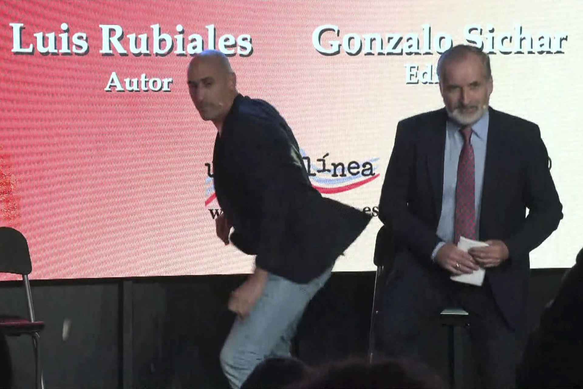 Captura de video del momento en el que Luis Rubiales, expresidente de la Real Federación Española de Fútbol, fue atacado por un hombre que le tiró huevos durante la presentación este jueves de su libro "Matar a Rubiales". Al grito de "sinvergüenza", un desconocido irrumpió en el acto y lanzó dos huevos que esquivó Rubiales. El atacante fue reducido y sacado de la sala y el acto continúa sin más incidentes. EFE/Alberto Lozano