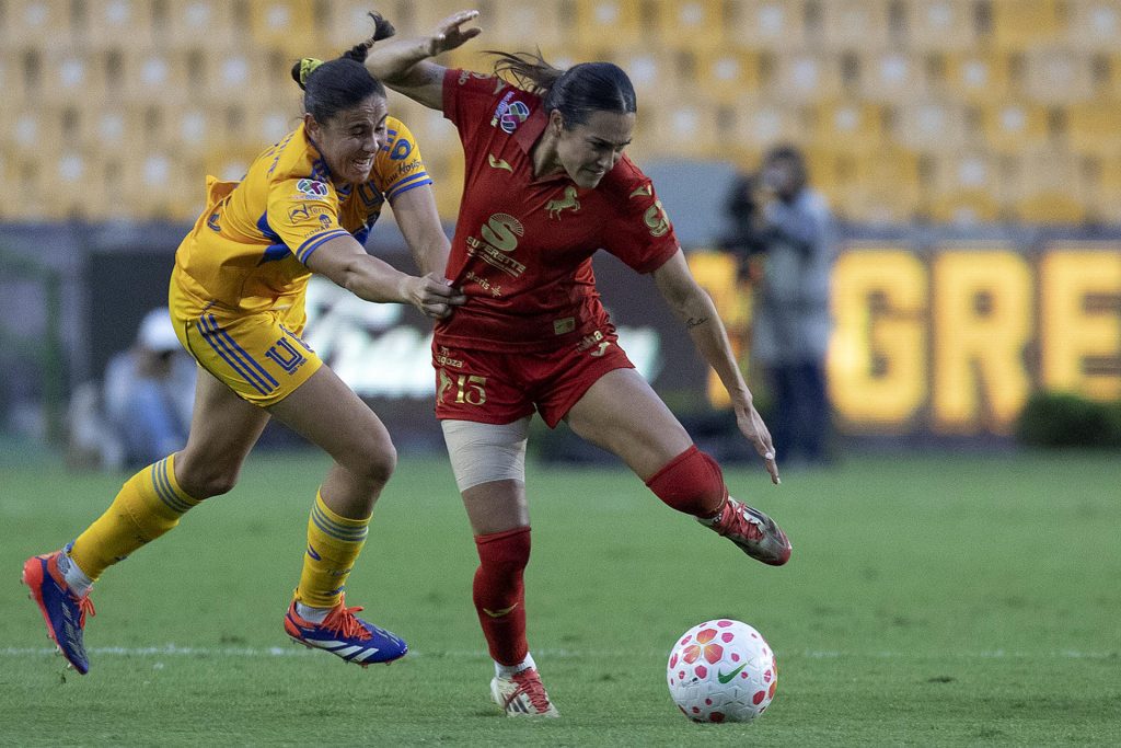 Jimena López (i), de Tigres, disputa un balón con Jasmine Casarez (c), de Juárez, durante un partido de vuelta de los cuartos de final de la Liga MX Femenil entre Tigres y Juárez en el estadio Universitario, en San Nicolás de los Garza Nuevo León (México). EFE/Antonio Ojeda
