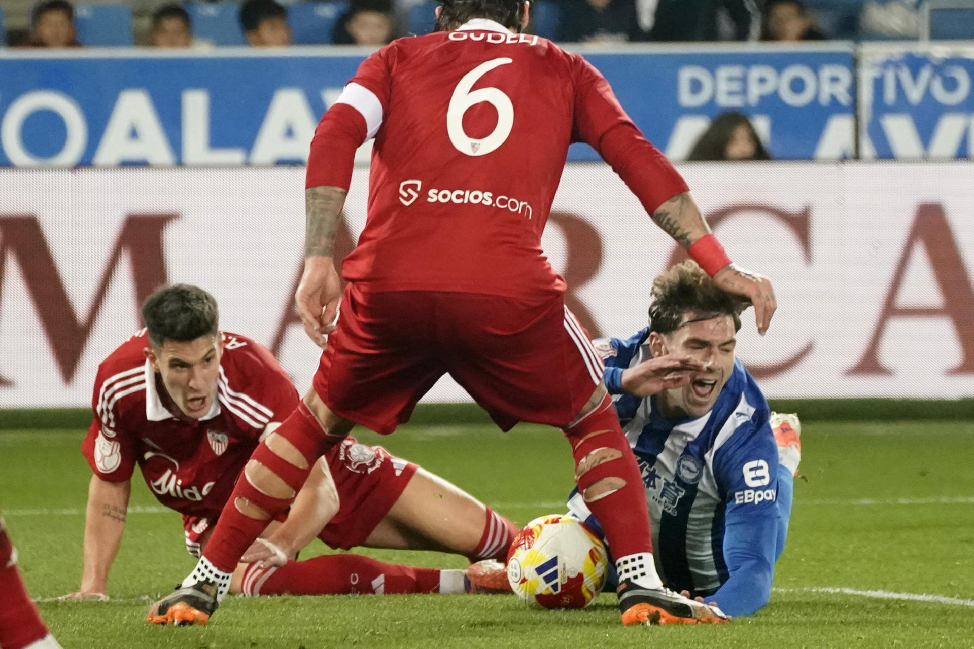 El delantero argentino del Alavés, Lucas Boyé (d), cae ante el defensor del Sevilla en la jugada que ha significado el penalti a favor del equipo alavés durante el encuentro correspondiente a los dieciseisavos de final de la Copa del Rey que disputaron Alavés y Sevilla en el estadio de Mendizorroza, en Vitora. EFE / L. Rico.