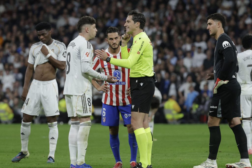 El árbitro Munuera Montero (2-d) conversa con el centrocampista del Real Madrid Fede Valverde (2-i), durante el partido de la jornada 29 de LaLiga que Real Madrid y Atlético de Madrid disputaron este domingo en el estadio Santiago Bernabéu. EFE/Juanjo Martín
