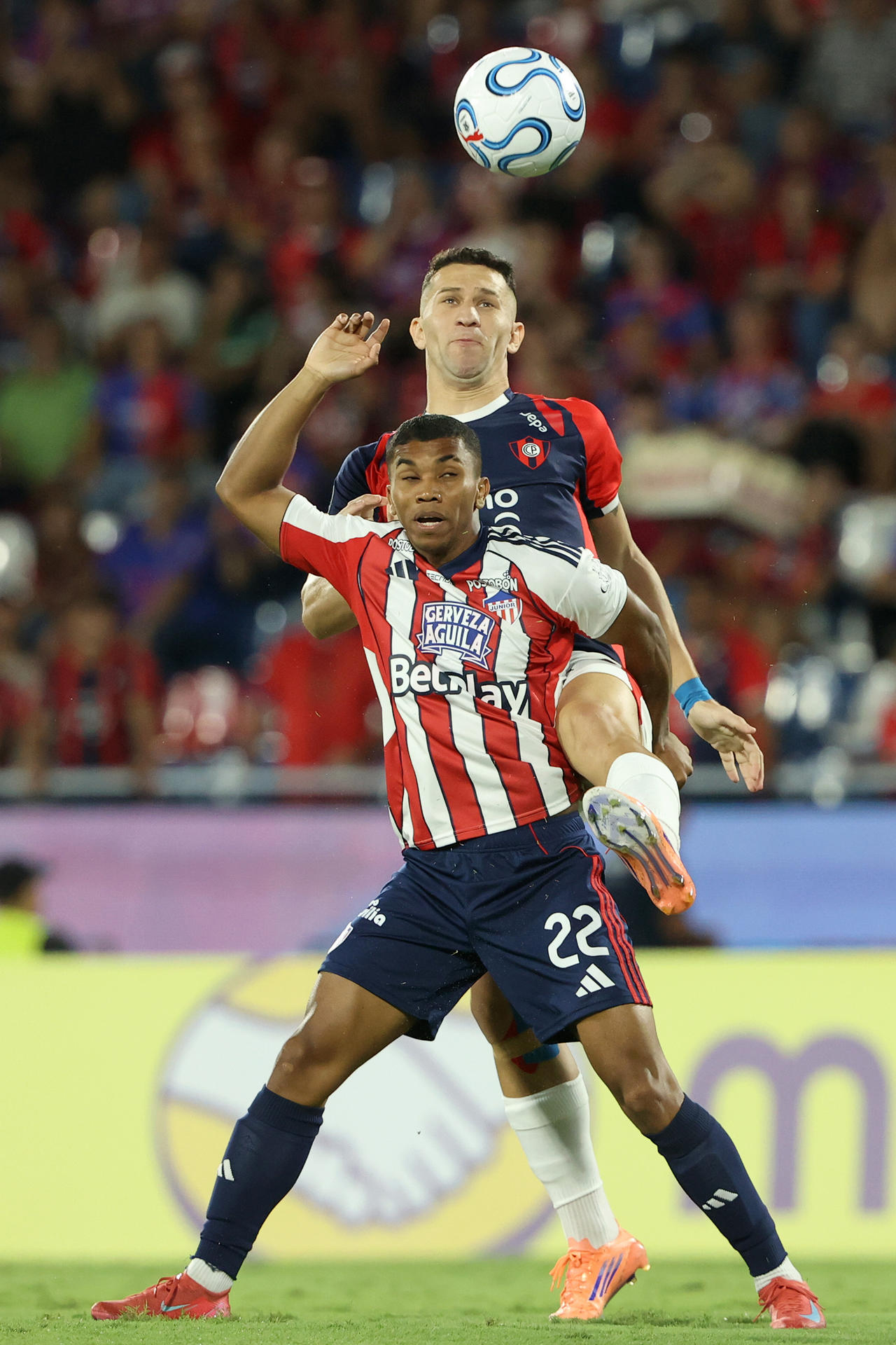 Jorge Morel (arriba), de Cerro Porteño, disputa el balón con Jesús Rivas, de Junior de Barranquilla, en un partido de la fase de grupos de la Copa Libertadores entre Cerro Porteño y Junior de Barranquilla en el estadio La Nueva Olla en Asunción (Paraguay). EFE/Juan Pablo Pino