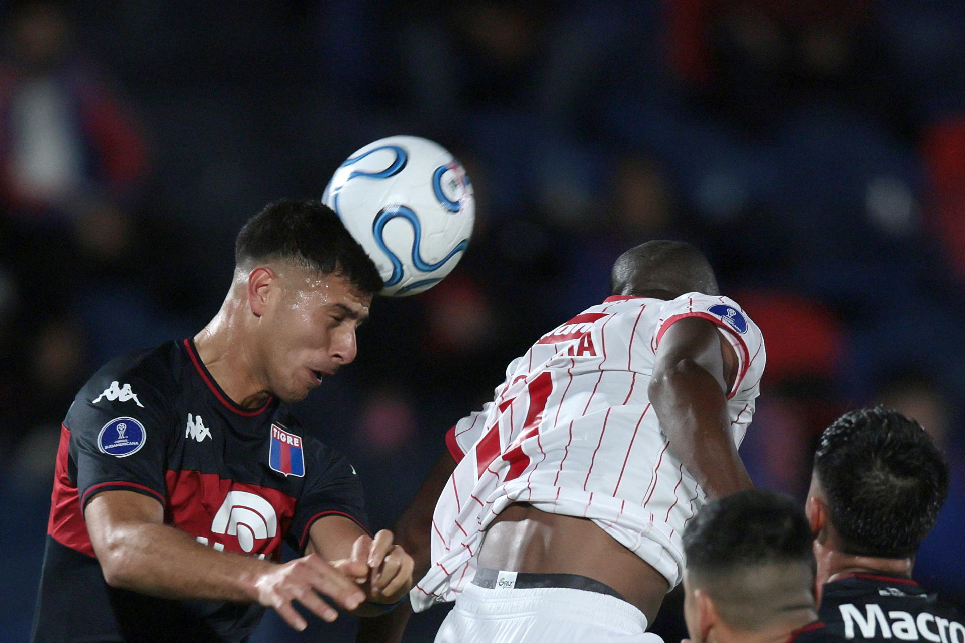 Alan Barrionuevo (i), de Tigre, disputa un balón con Andrés Mosquera, del América, en un partido del grupo A de la Copa Sudamericana en el estadio José Dellagiovanna en Victoria (Argentina). EFE/Adán González