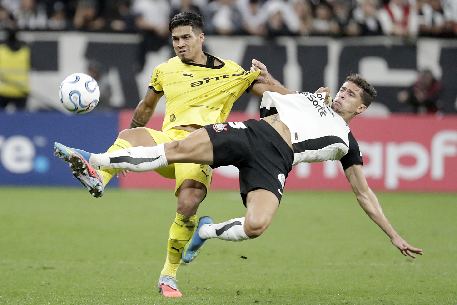El defensor de Corinthians Gabriel Paulista (d) sujeta por la camiseta al extremo de Peñarol Matias Arezo durante el partido de la tercera jornada de la fase de grupos de la Copa Libertadores jugado este jueves en el estadio Neo Química Arena de Sao Paulo. EFE/ Sebastiao Moreira