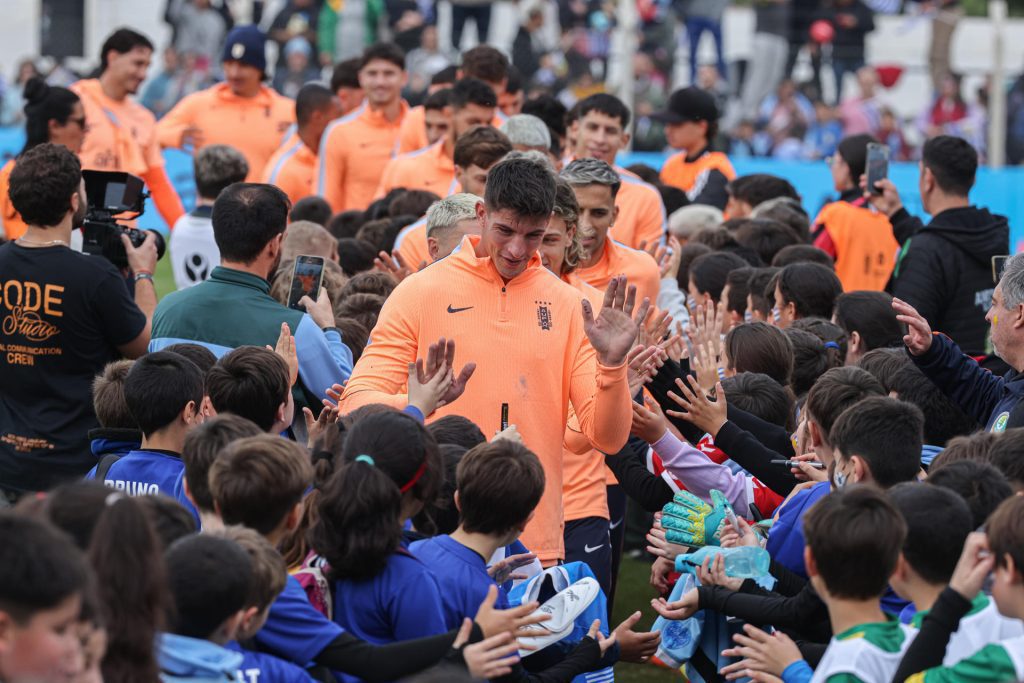 Jugadores de la selección de fútbol de Uruguay saludan niños durante un evento de despedida este viernes en el estadio Tito López López, en Pando, Canelones. EFE/ Gastón Britos
