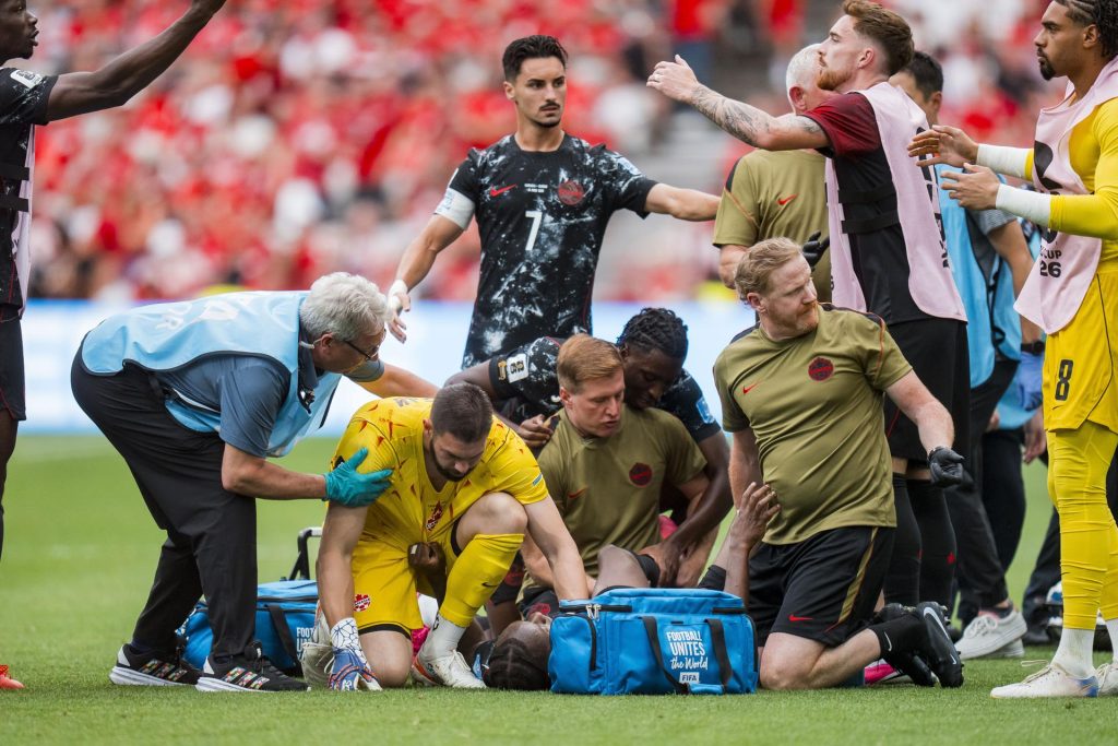 El portero canadiense Maxime Crepeau (2-i) consuela a su compañero Ismael Koné (tendido en la grama) quien sufrió una grave lesión en la pierna izquierda tras una falta de Assim Madibo, de Catar. EFE/EPA/BOB FRID