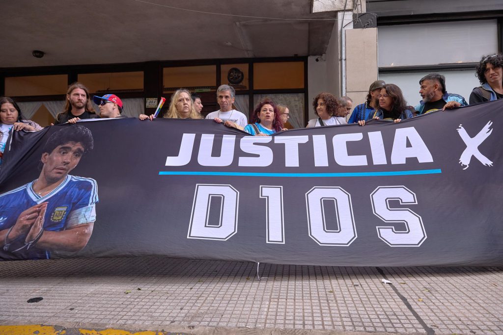 Fotografía de archivo, tomada el pasado 14 de abril, de un grupo de ciudadanos al exigir justicia durante el juicio por la muerte del legendario futbolista argentino Diego Armando Maradona, a las afueras del tribunal de San Isidro, en Buenos Aires (Argentina). EFE/Adán González
