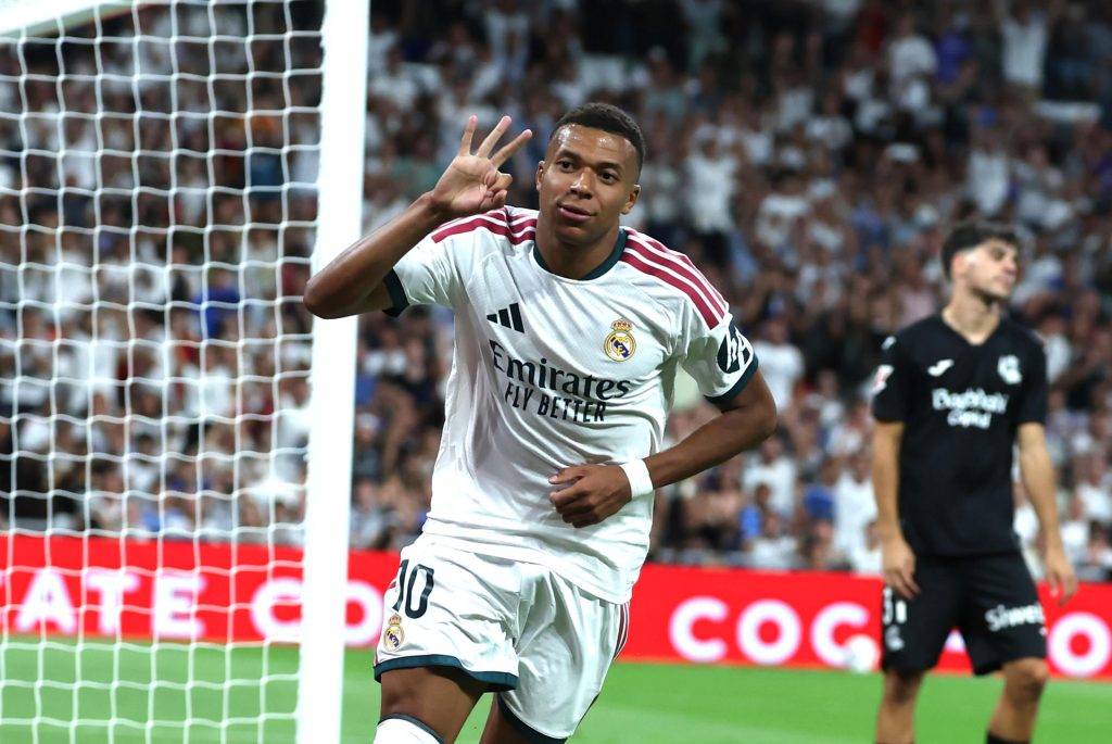 El delantero francés del Real Madrid Kylian Mbappé celebra su tercer gol durante el encuentro correspondiente a la primera jornada de LaLiga que Real Madrid y Real Sociedad disputan este miércoles en el Santiago Bernabéu, en Madrid. EFE/ Kiko Huesca
