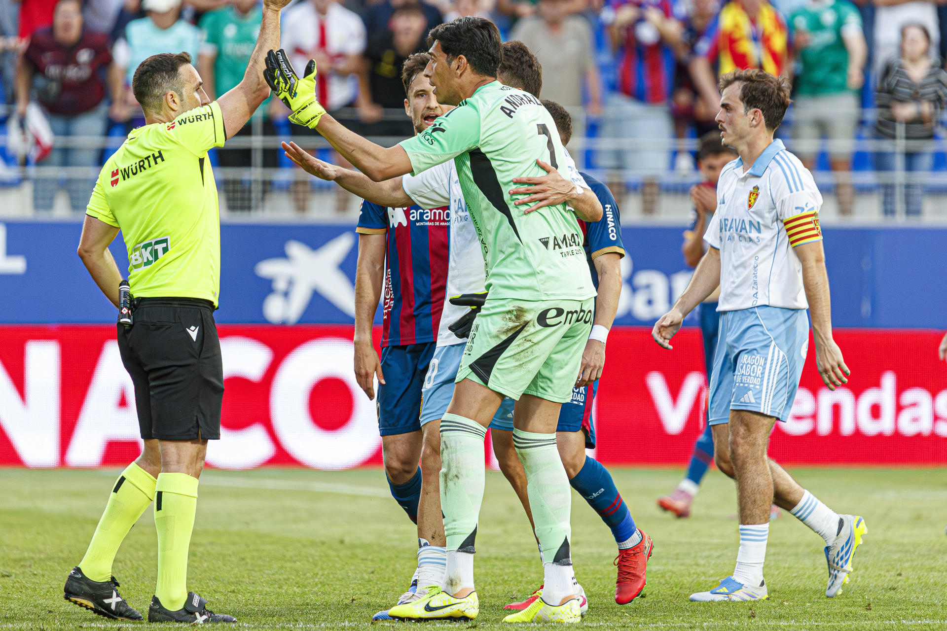 Imagen tomada en el partido entre la S.D.Huesca y el Real Zaragoza, momento en el que el árbrito del partido, Dámaso Arcediano (IZ), muestra la tarjeta roja a Esteban Andrada (C).EFE. JAVIER BELVER